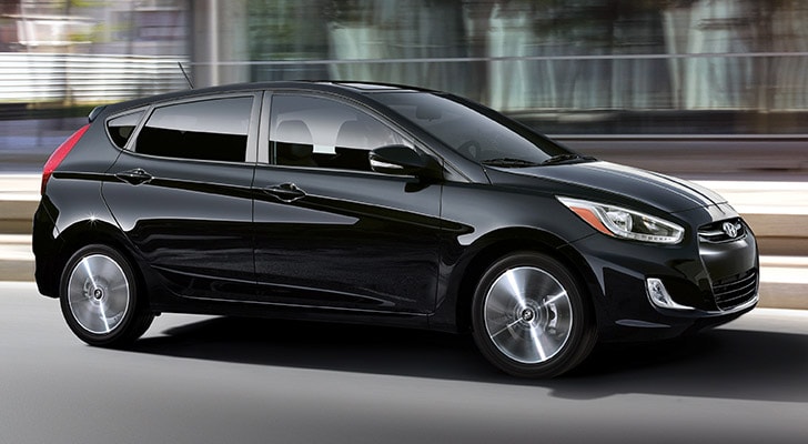 The exterior view in front of the Hyundai Accent compact black hatchback car with five doors